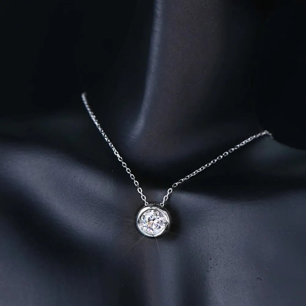 Silver solitaire bezel-set pendant necklace with a delicate chain.