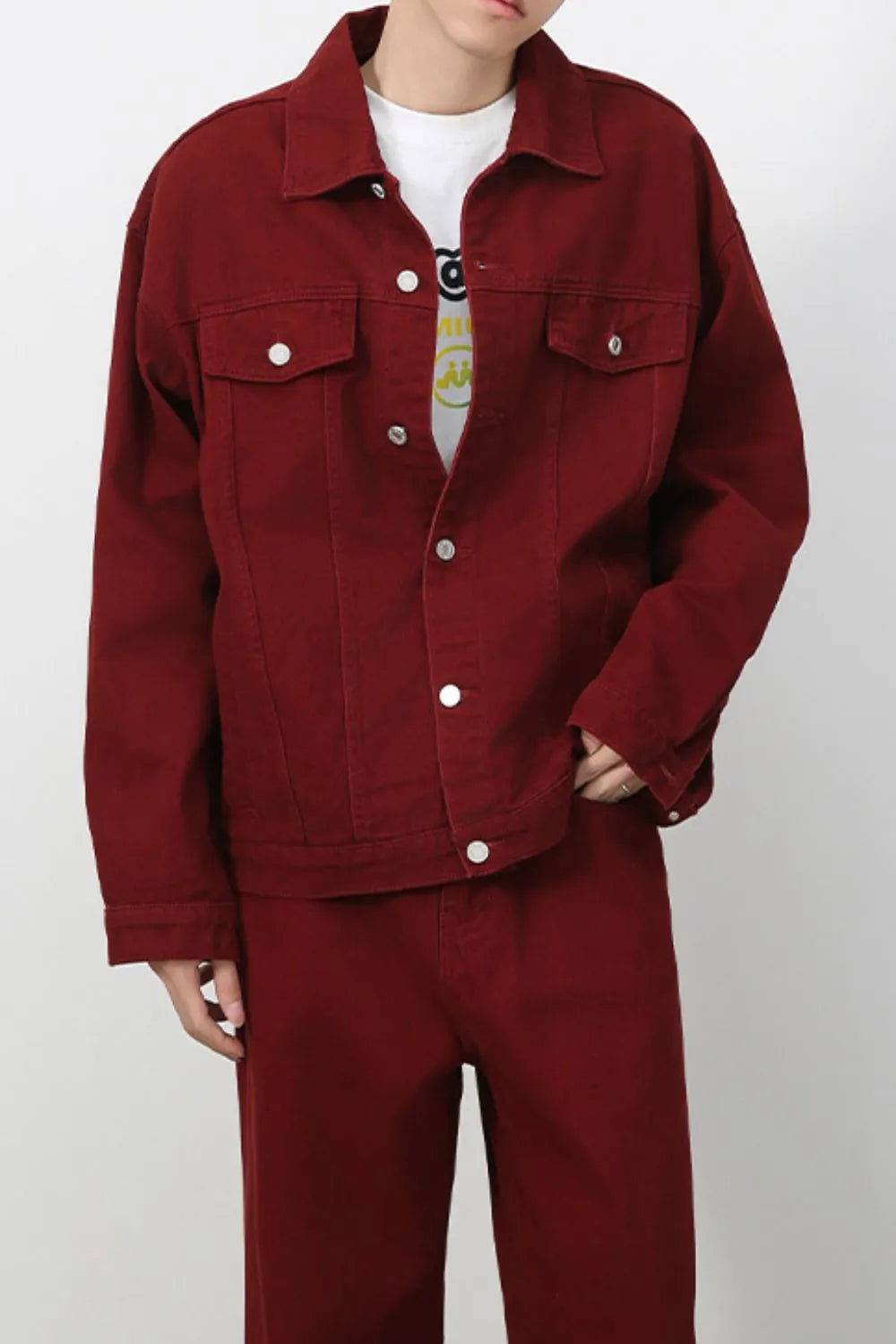 Burgundy denim trucker jacket with button closure and chest pockets.