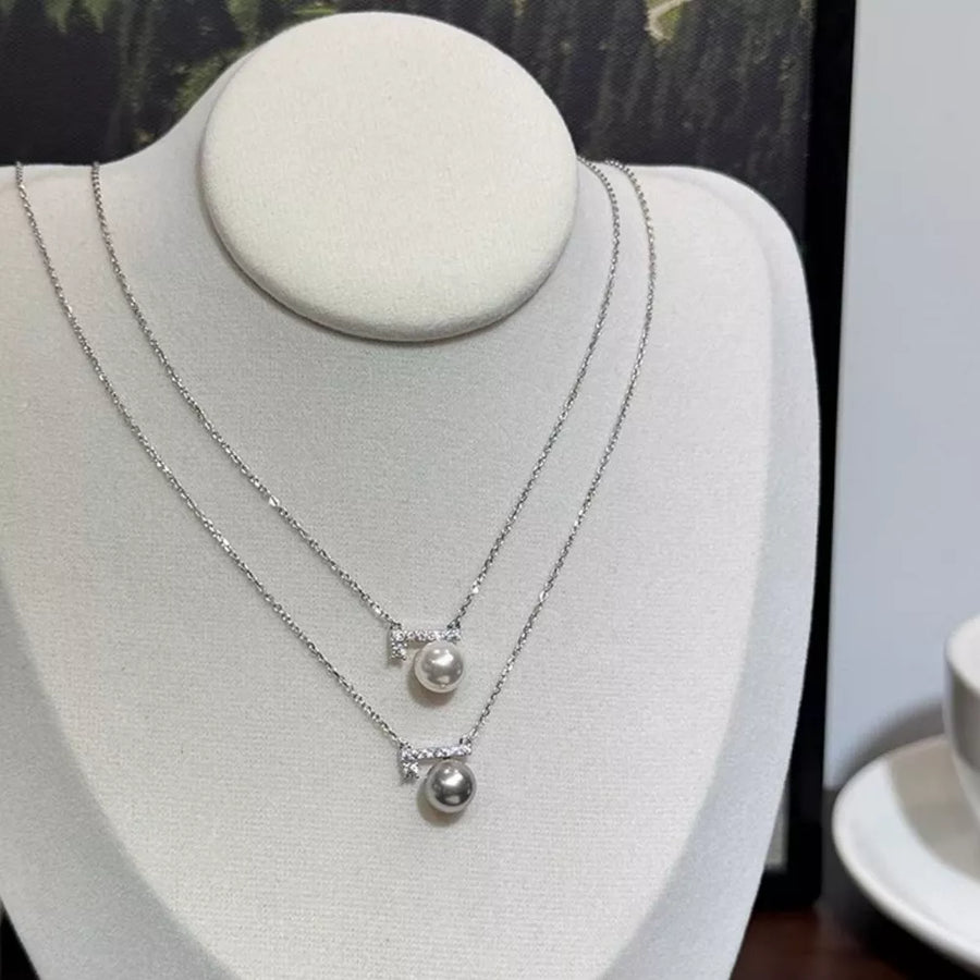 Lustrous pearl pendant necklaces with zircon accents, one light gray pearl, one cream pearl.