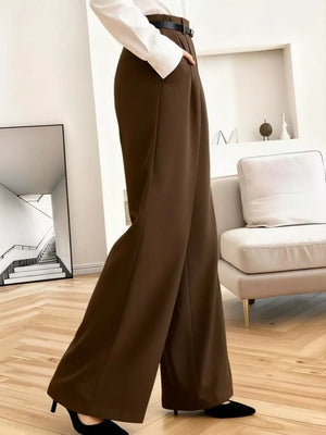 Brown high-waisted pleated wide leg maternity trousers with a belt and pockets.