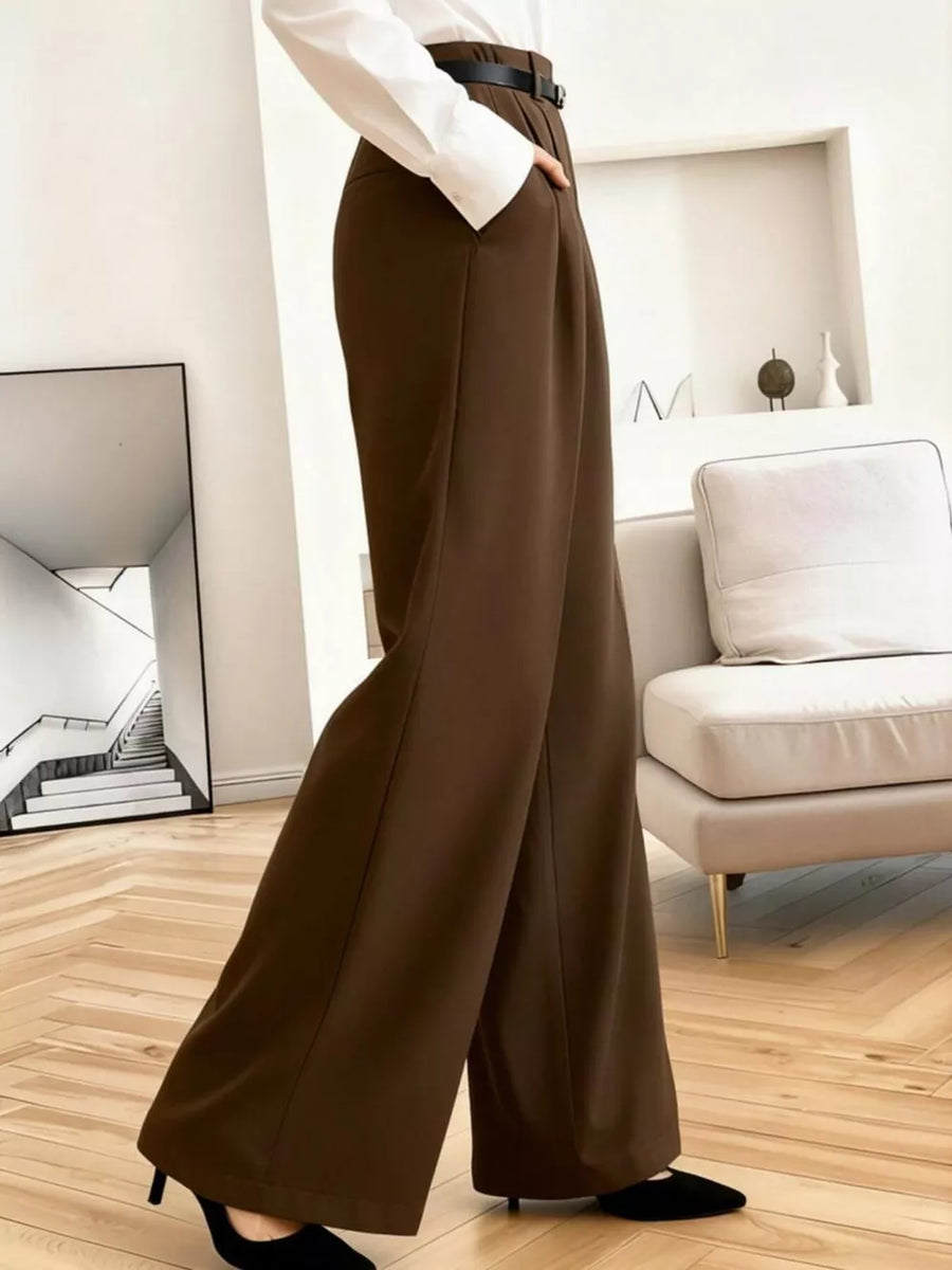 Brown high-waisted pleated wide leg maternity trousers with a belt and pockets.