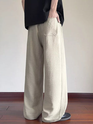 Cream wide-leg drawstring sweatpants with a textured fabric and back pocket.
