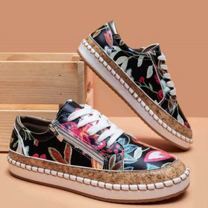 Floral zip-up sneakers with cork sole and white laces.