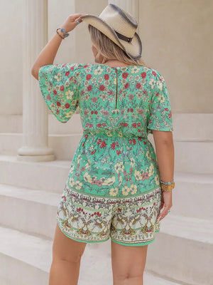 Plus-size green floral romper with cinched waist and short flutter sleeves.