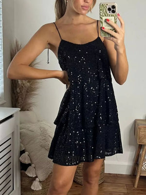 Black sequin mini dress with tiered skirt and tie straps.