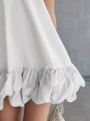 White V-neck mini dress with bubble hem detail and ruffled trim.