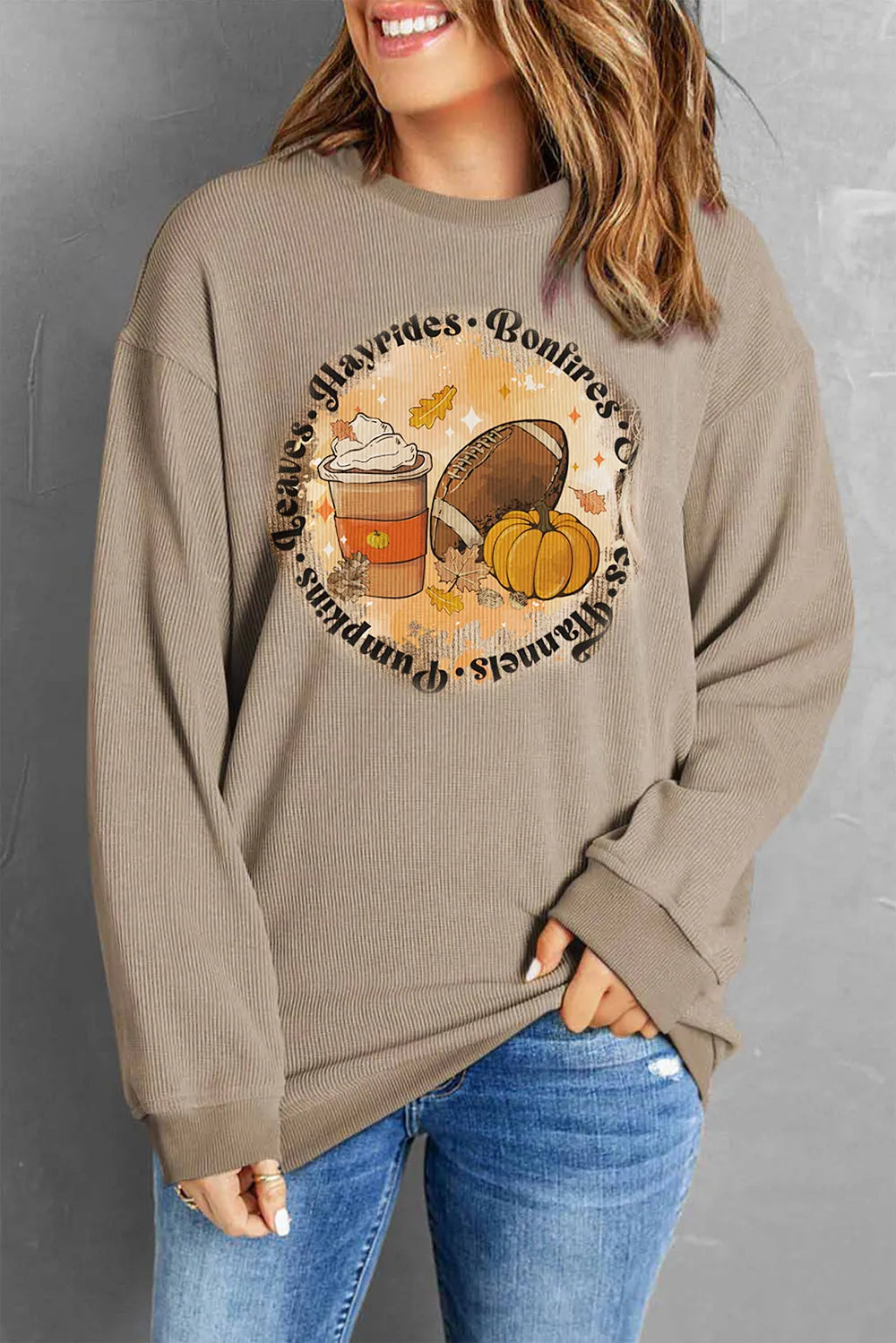 Khaki ribbed knit sweatshirt with a fall graphic featuring a coffee cup, football, and pumpkin.