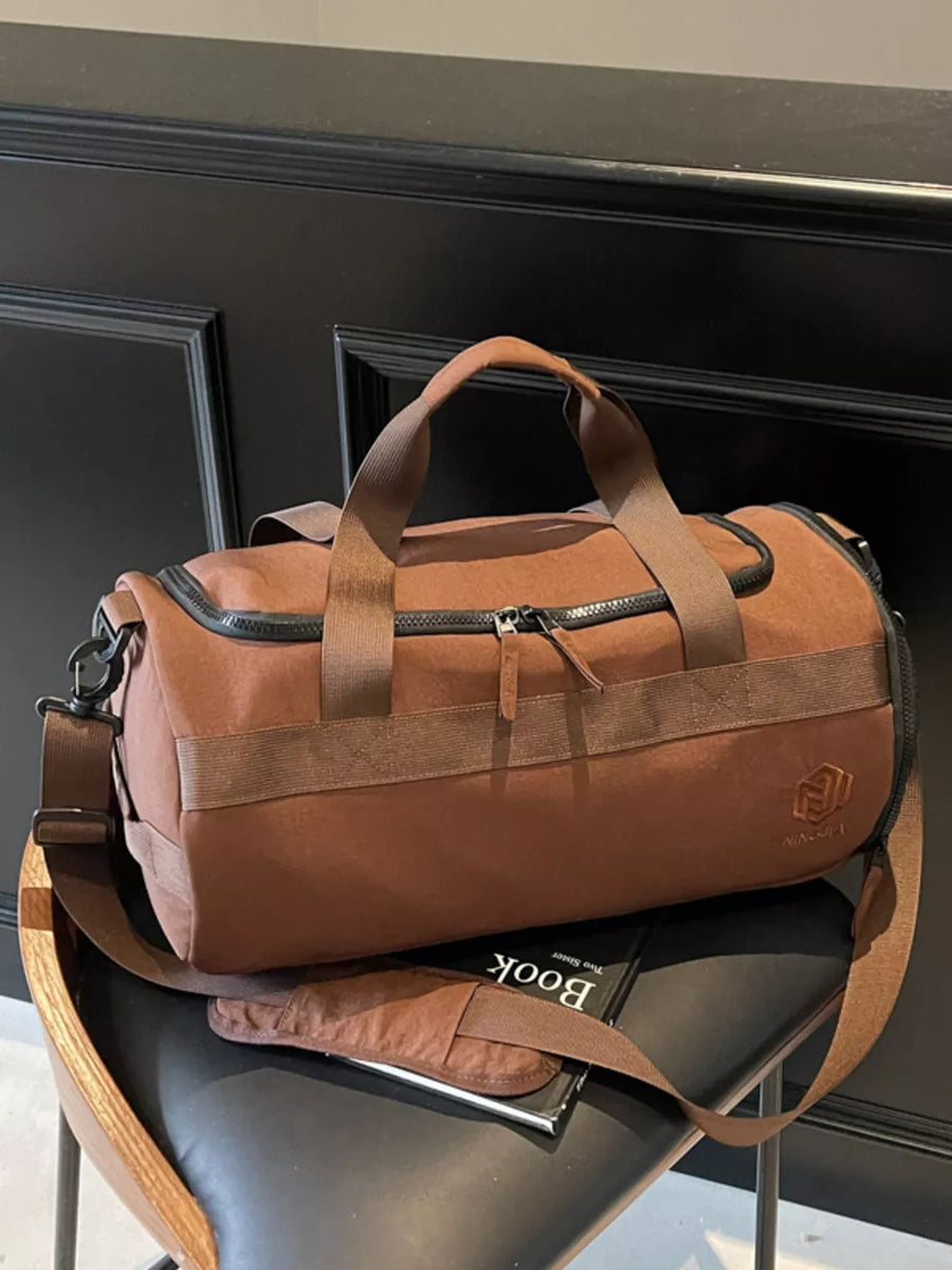 Brown Oxford cloth duffel bag with carry handles and adjustable strap.