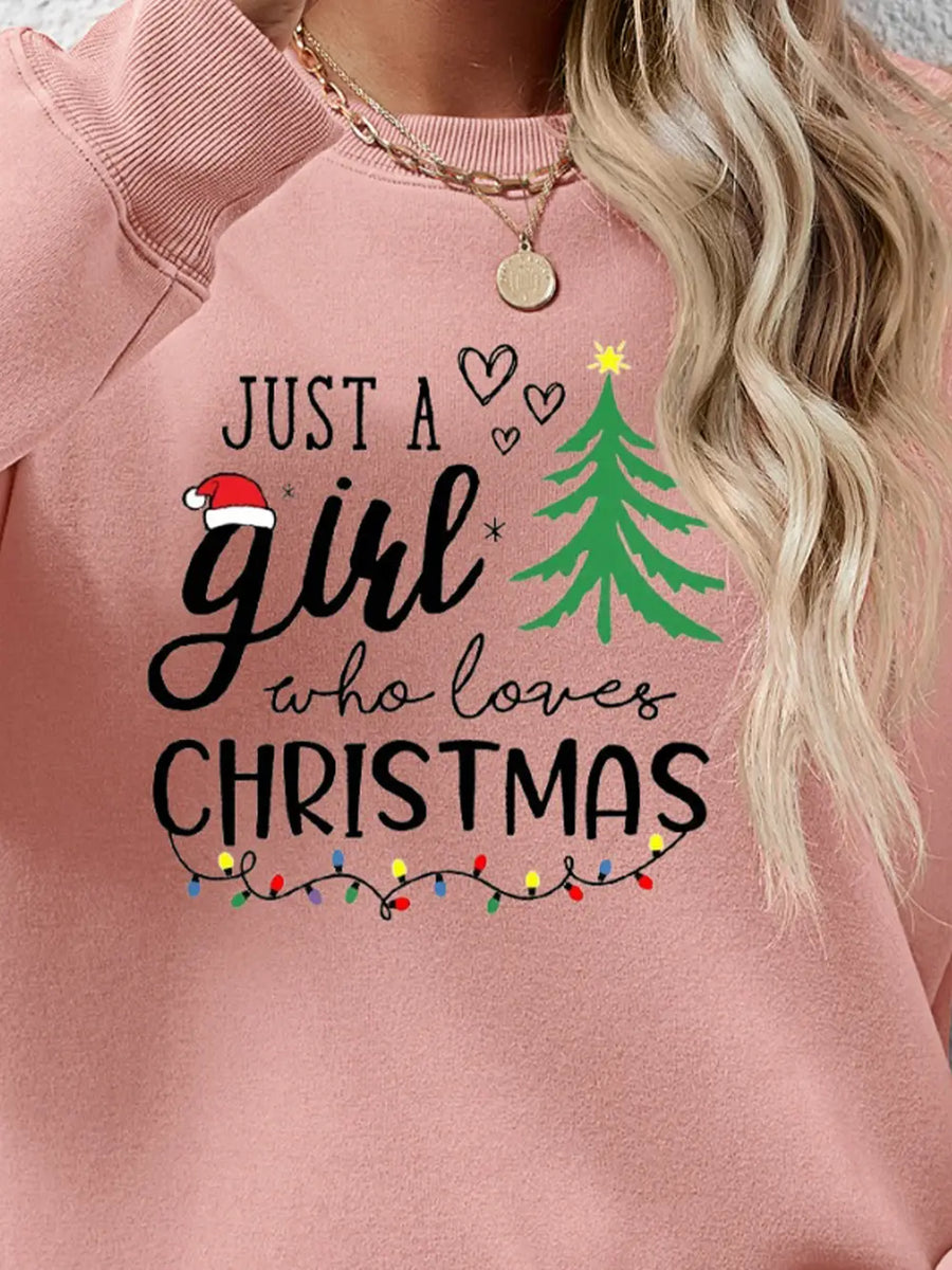 Blush pink crewneck sweatshirt with "Just a girl who loves Christmas" graphic and string lights.