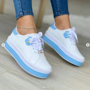 White lace-up platform sneakers with blue accents and a thick sole.