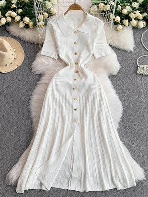 White ribbed knit midi dress with collar, short sleeves, and gold button detail.