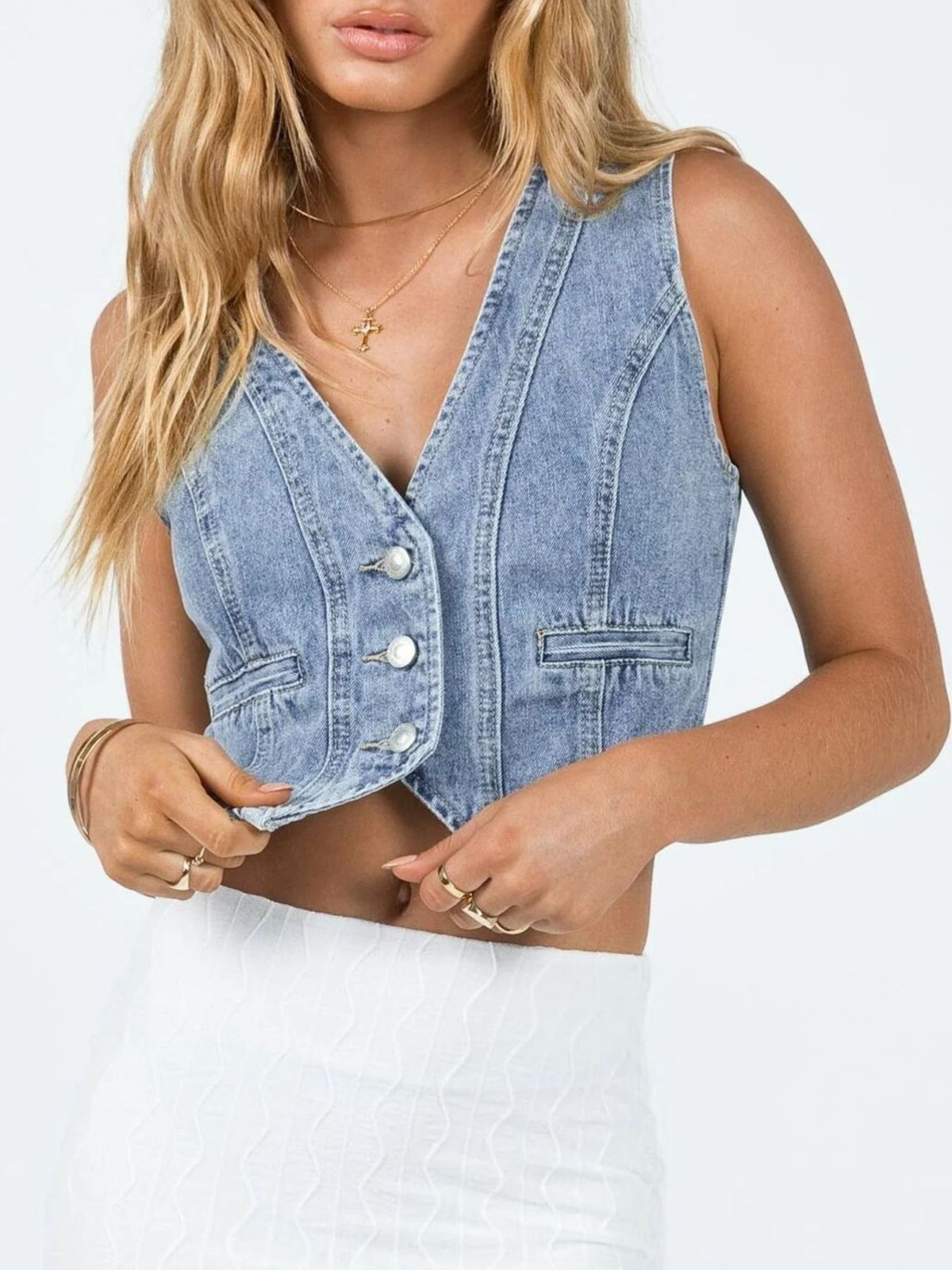 Chic V-neck button-up denim vest with cropped length and two front pockets.