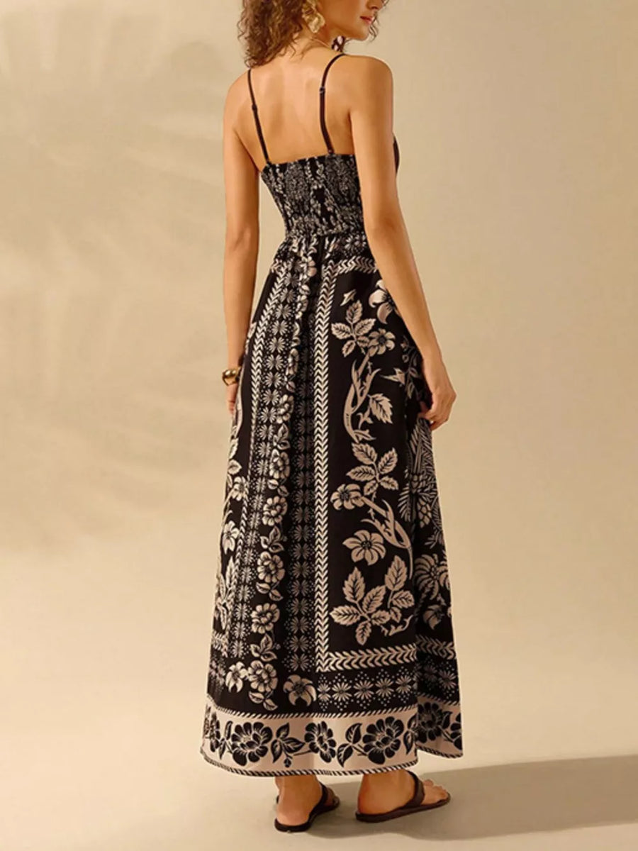Black floral print spaghetti strap maxi dress with smocked waist and bohemian pattern.