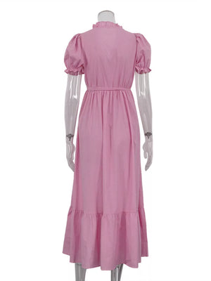 Pink midi dress with ruffled neckline, puff sleeves, cinched waist, and tiered hem