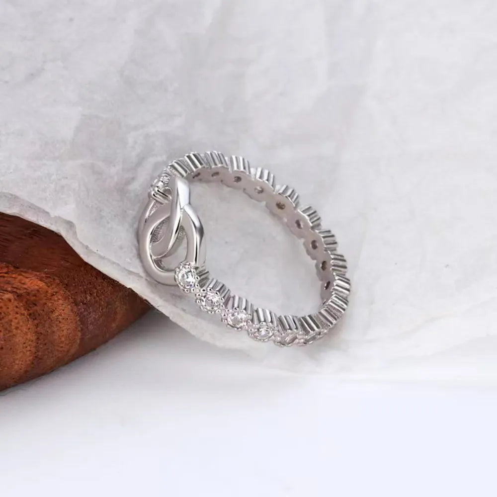 Silver interlocked pavé eternity ring with cubic zirconia accents.