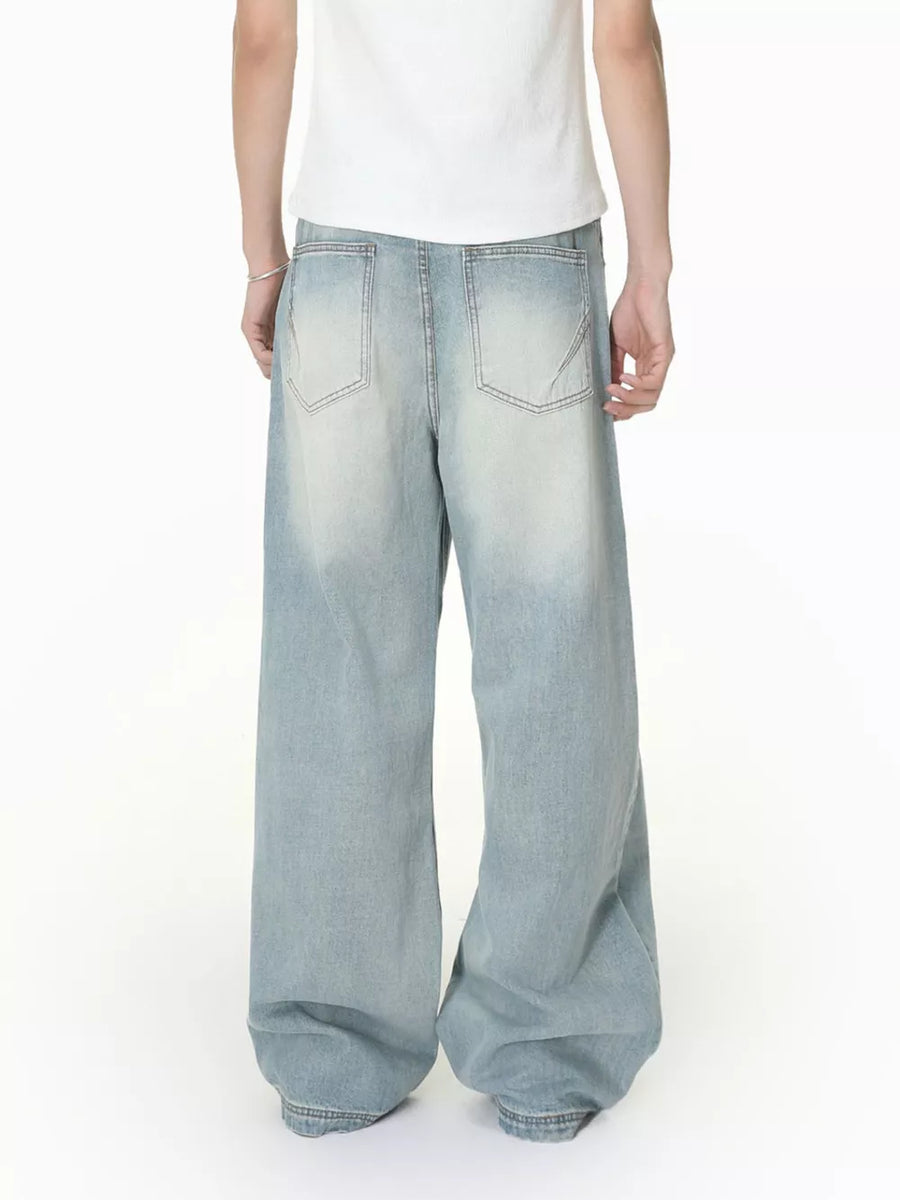 Men's light wash wide-leg jeans with vintage distressing and classic back pockets.