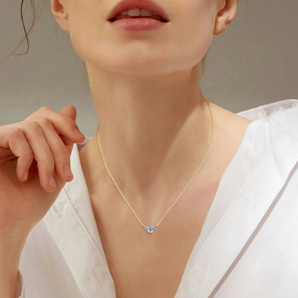 Gold necklace with a celestial trio diamond pendant on a woman.