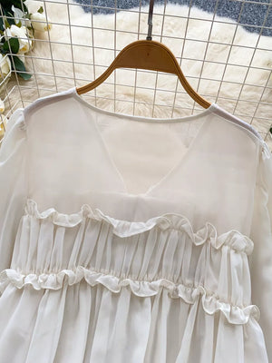 White chiffon blouse with ruffled V-neck and tie-front detail.