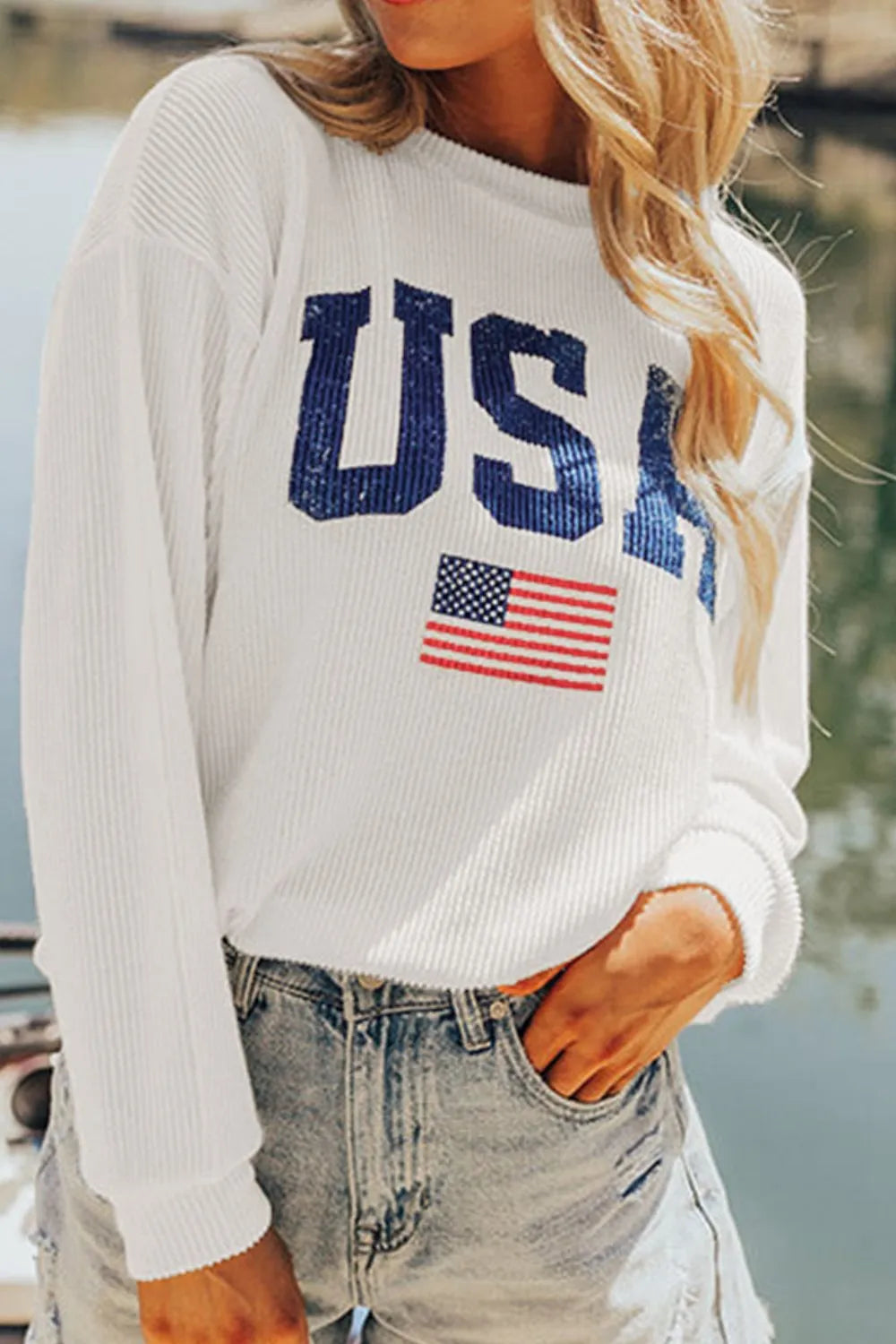 White ribbed knit sweatshirt with USA graphic and American flag detail.