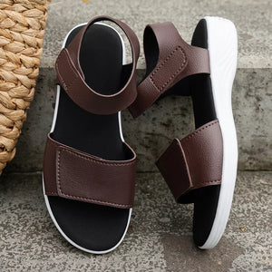 Brown adjustable open-toe platform sandals with chunky white soles and velcro straps.