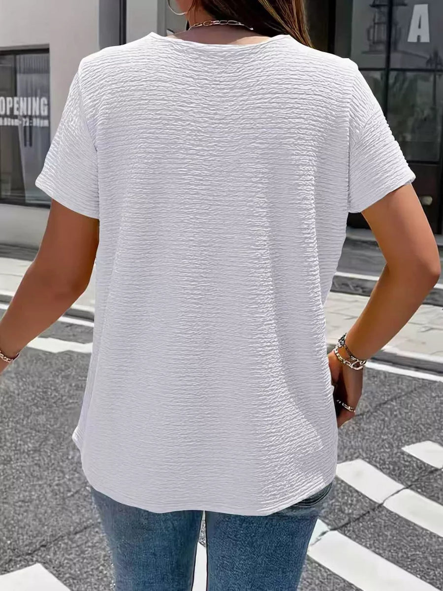 Textured white short sleeve blouse with a crew neck, shown from the back.
