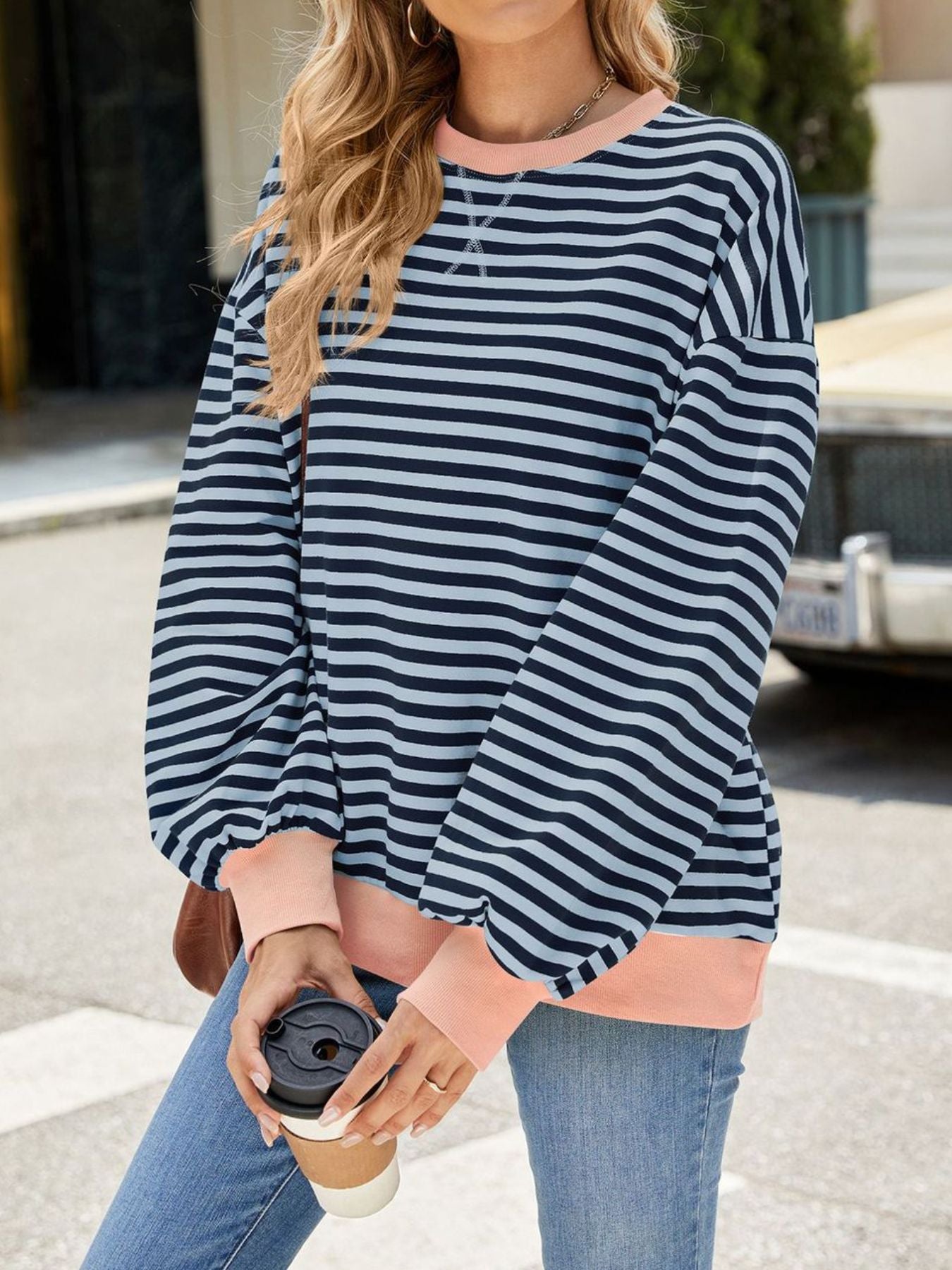 Striped crew neck sweatshirt in navy and light blue with coral cuffs and hem.
