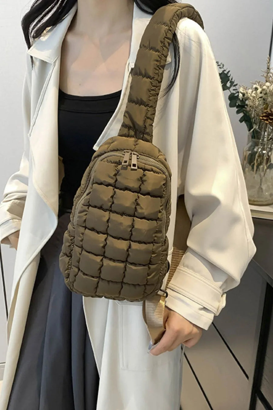 Padded sling bag in Army Green with quilted pattern and top handle.