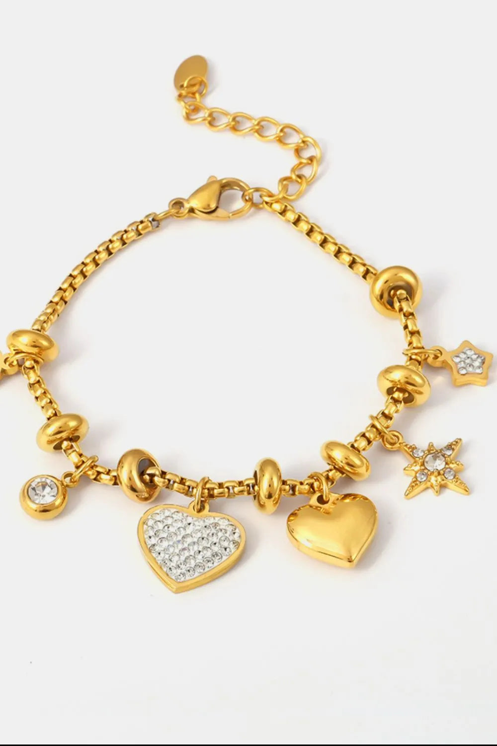 Gold charm bracelet with heart and star charms, featuring cubic zirconia accents.
