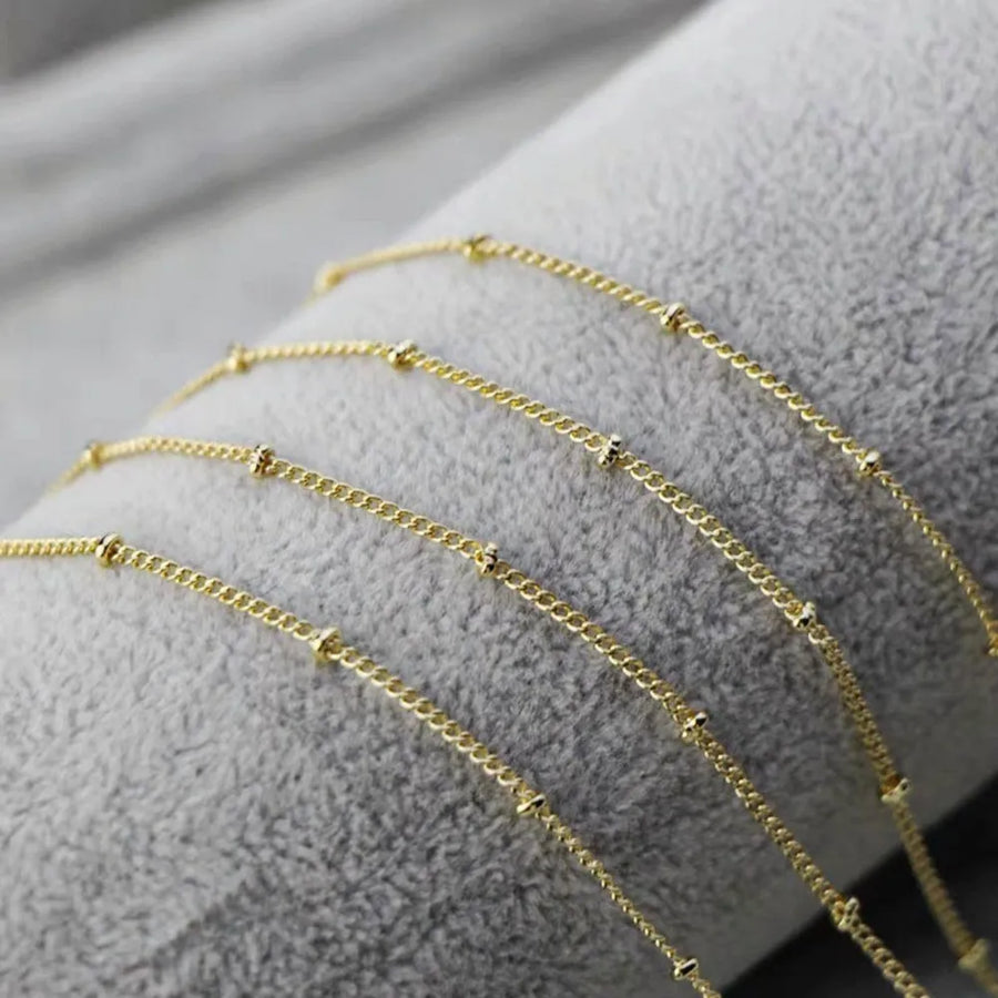 Gold beaded chain necklace with a delicate curb link.