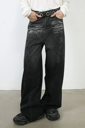 Dark denim palazzo trousers with a wide leg and sculpted seams, styled with a belt.