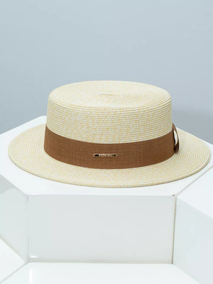 Elegant straw boater hat in beige with a brown ribbon band and gold detail.