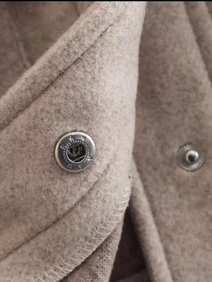 Beige trucker jacket detail showing snap buttons and textured fabric.