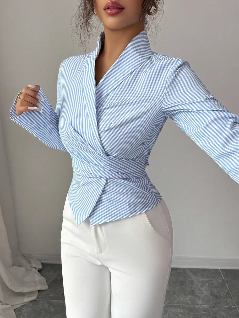 Blue striped long sleeve wrap blouse with a cinched waist and pointed collar.