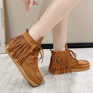 Brown suede moc-toe ankle boots with fringe and stud details.