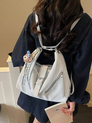 Light blue distressed leather shoulder bag with buckle detail and diagonal zippers