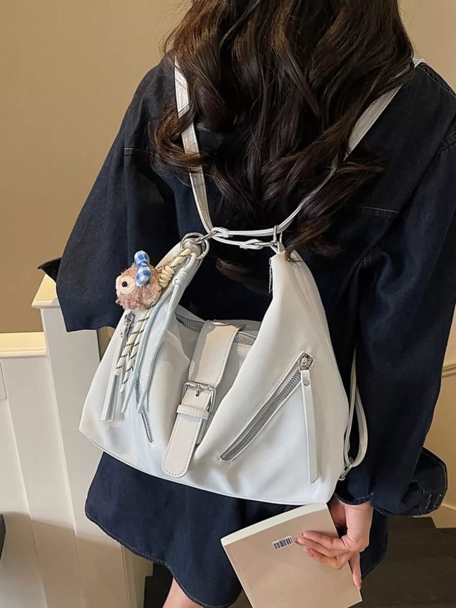 Light blue distressed leather shoulder bag with buckle detail and diagonal zippers