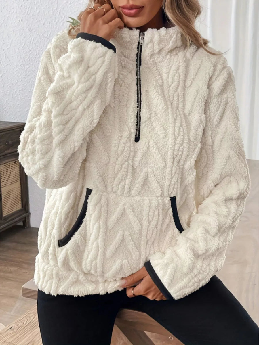 White sherpa half zip sweatshirt with textured pattern and black trim details.
