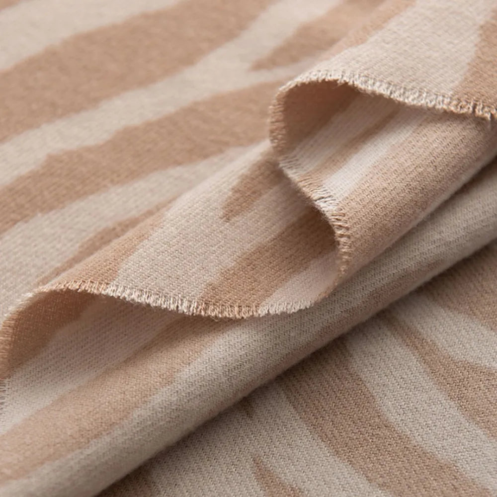 Zebra stripe wool scarf in khaki with frayed edges.