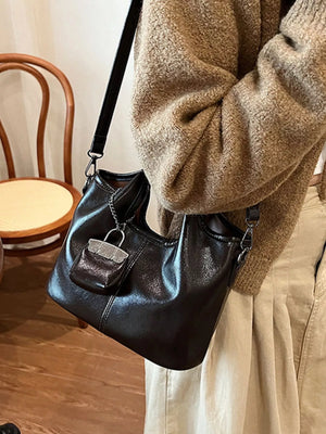 Black PU leather crossbody bag with a small attached purse and silver hardware.