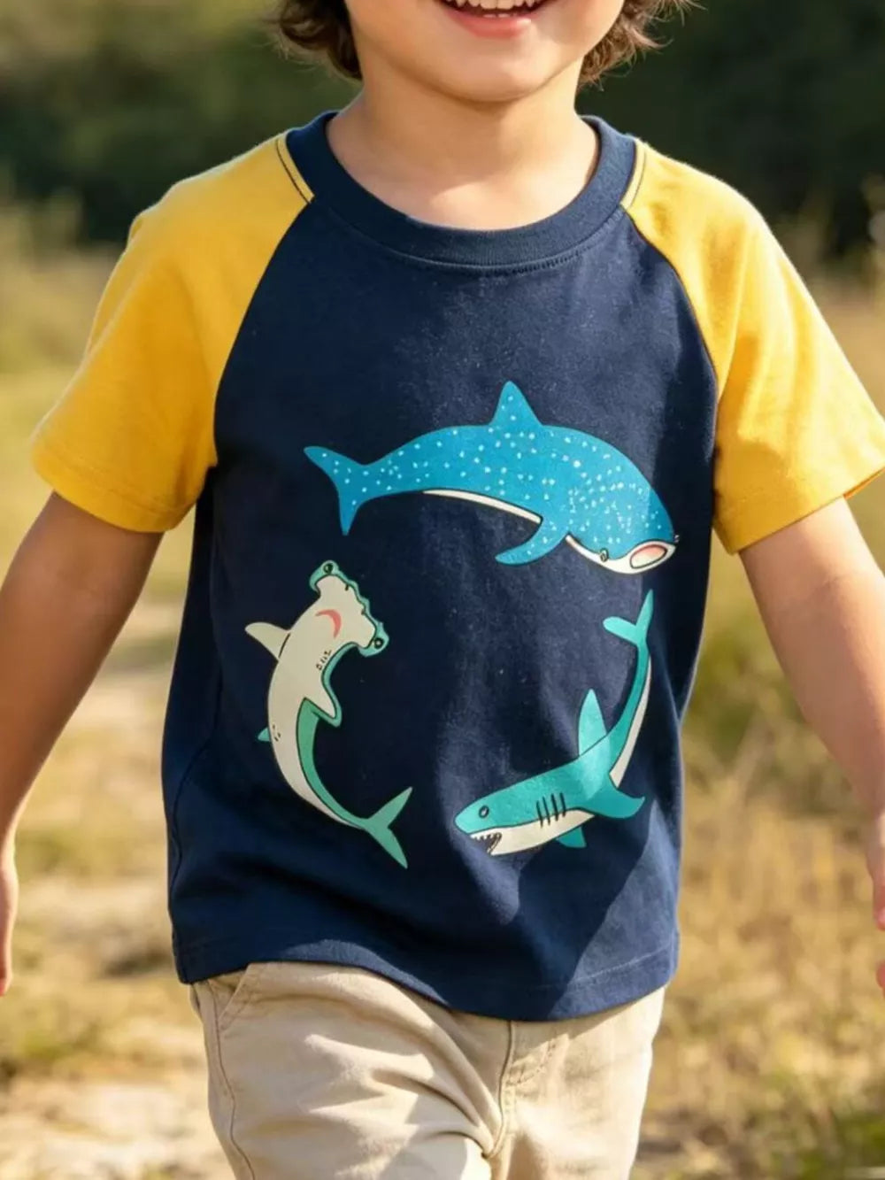 Navy cotton t-shirt with yellow raglan sleeves and a graphic of three playful sharks.