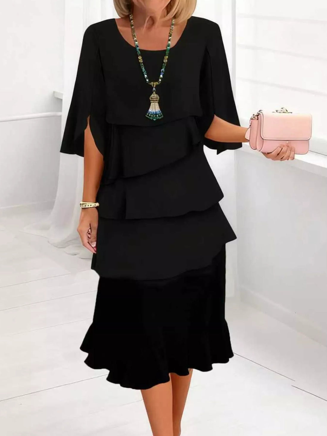 Black tiered ruffle dress with flutter sleeves and a ruffled hem.