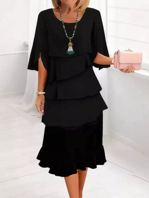 Black tiered ruffle dress with flutter sleeves and a ruffled hem.