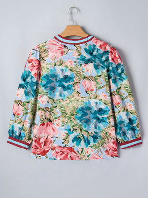 Women's cotton V-neck blouse with a bold floral print and striped cuffs.