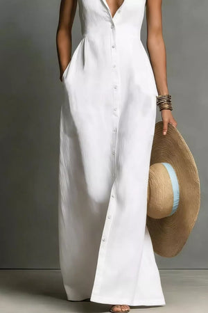 Chic white sleeveless maxi dress with button front and pockets, styled with a straw hat.
