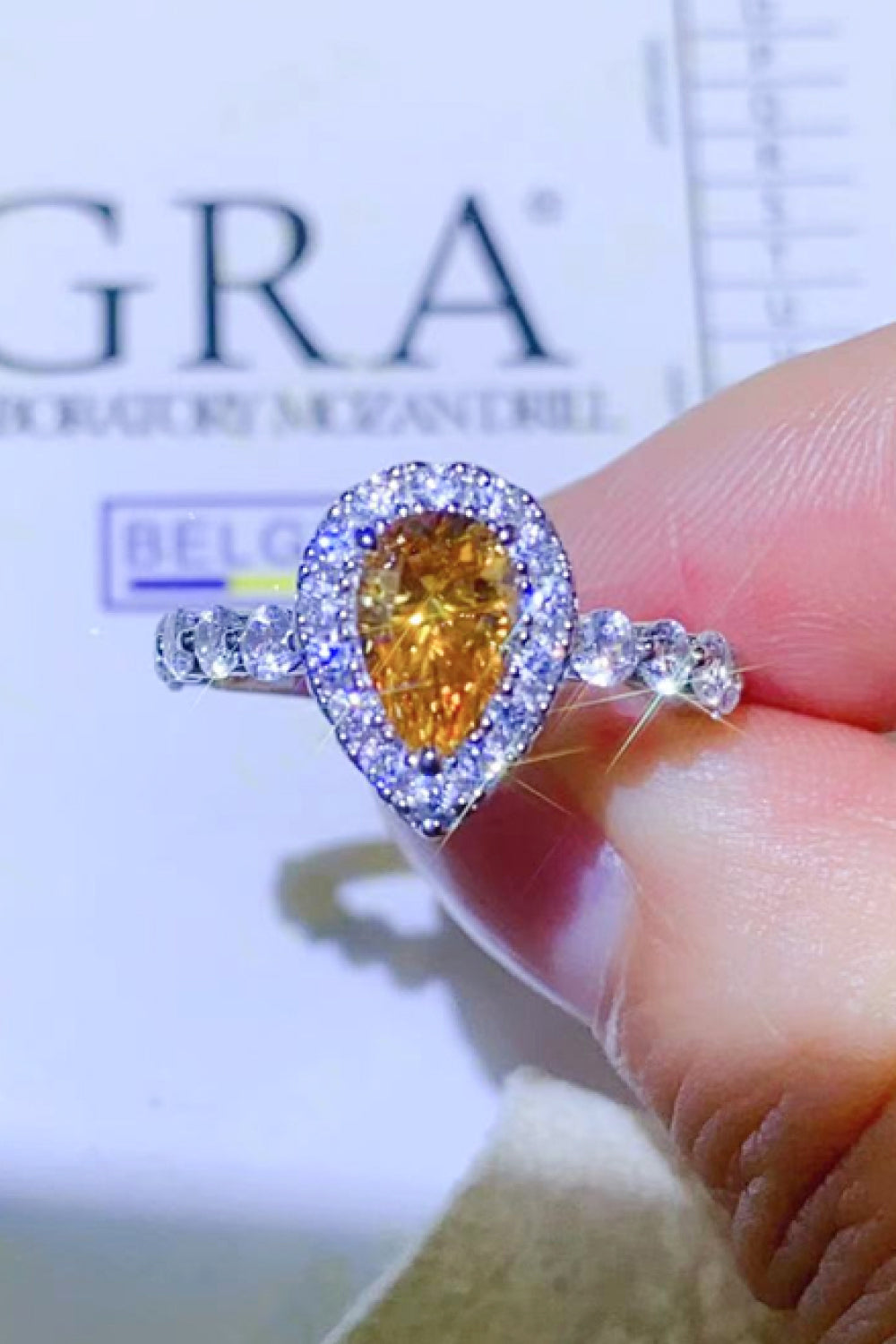Gold halo ring with pear-cut amber gemstone and diamond accents
