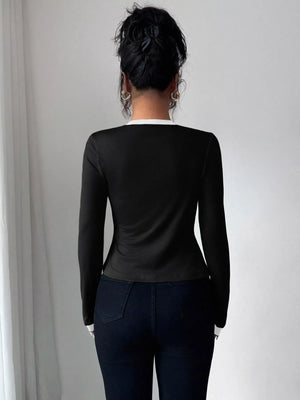 Black long sleeve top with white trim detail, part of a cardigan set.