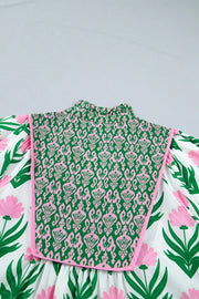 Playful floral blouse with puff sleeves, V-neck, and a green and pink patterned bib detail.