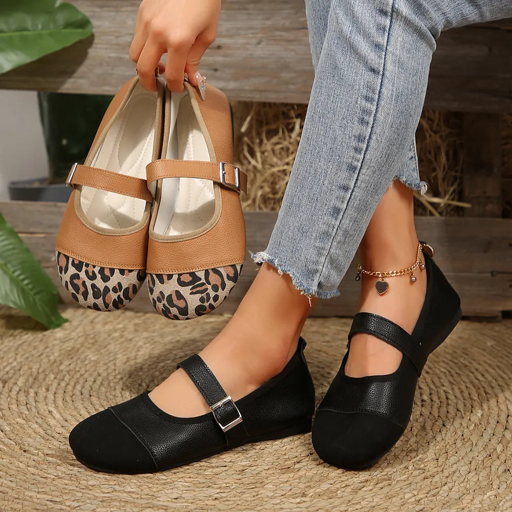 Black and brown leopard print cap-toe Mary Jane flats with buckle straps.
