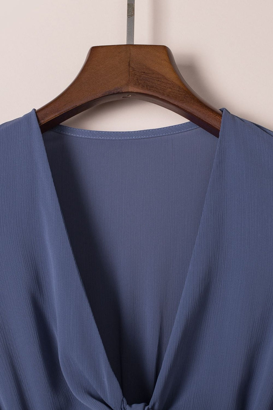 Dusty blue V-neck mini dress with ruffled bow-tie detail.