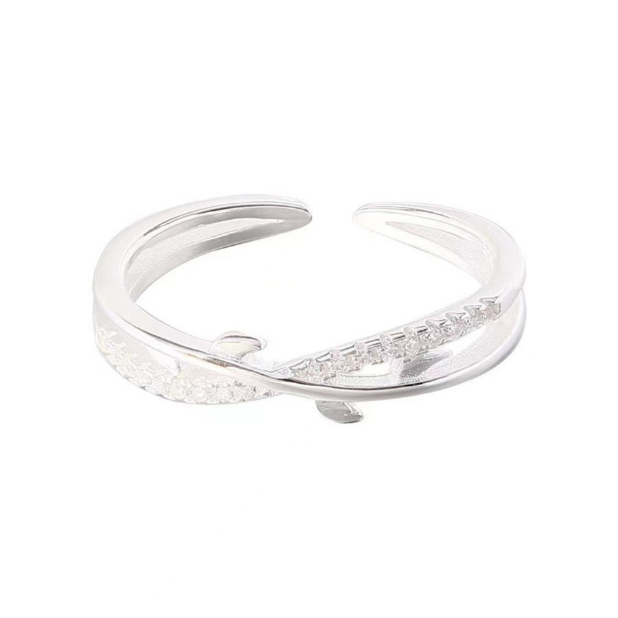 Sterling silver open ring with delicate crossover design and cubic zirconia accents.